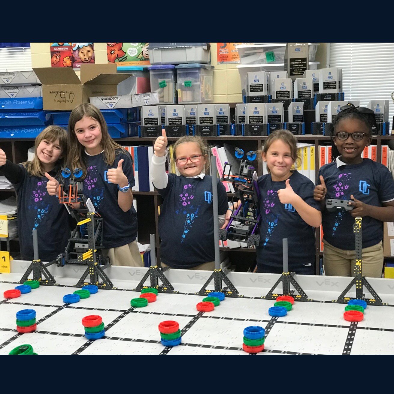 VEX IQ Robotics Competition team poses behind game field