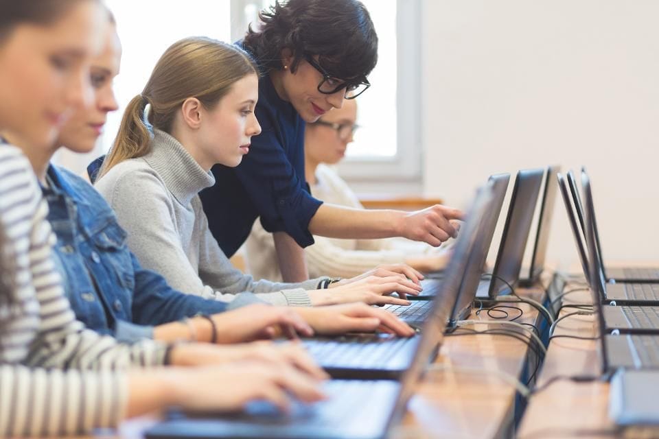 Small group of people working at computers, focus on woman