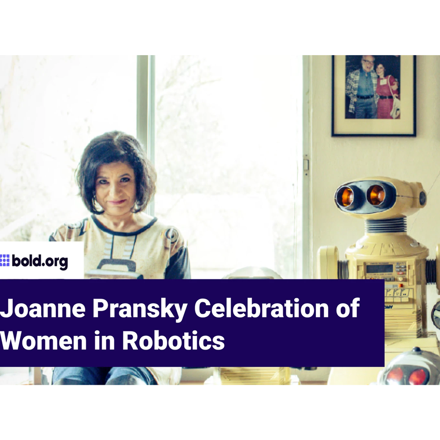 Joanne Pransky sits next to a robot.