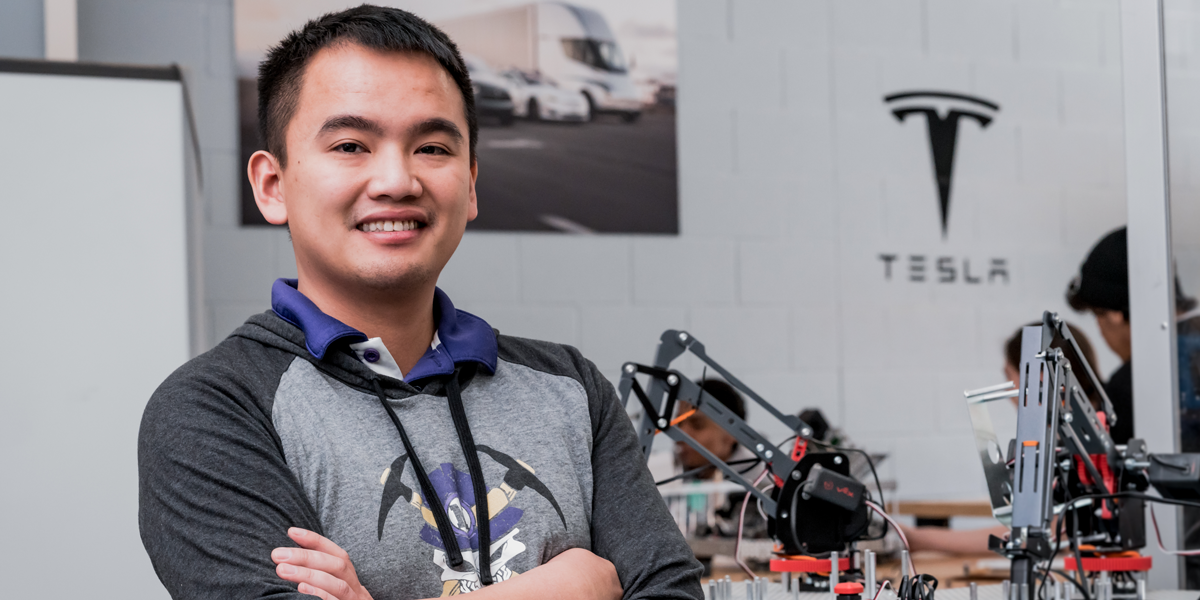 Student poses with robot