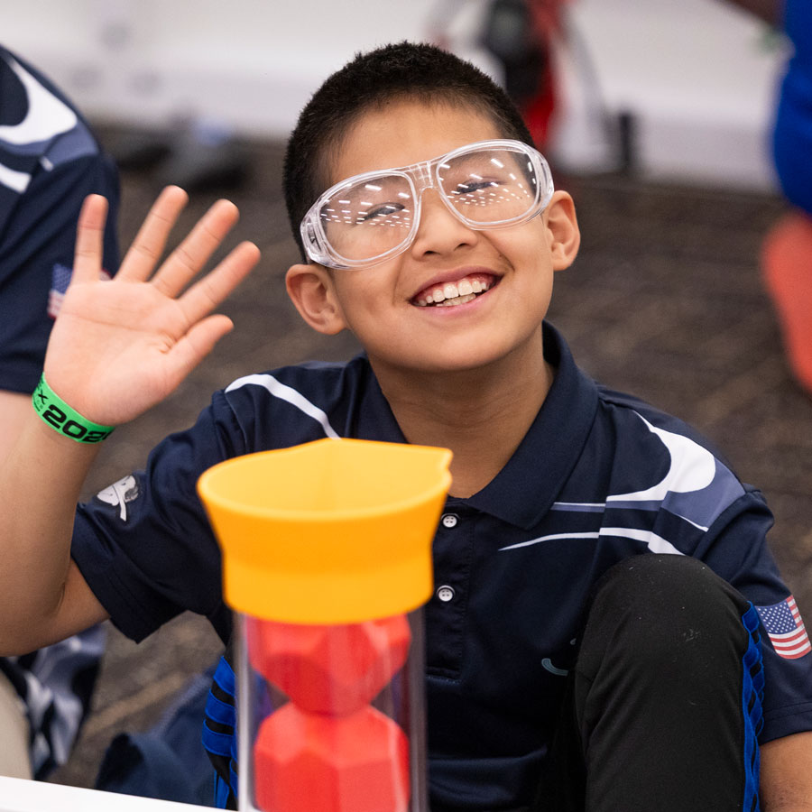 Participant poses by a field at the VEX Robotics World Championship